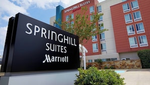 A sign for Springhill Suites Marriott with a modern building in the background. - SpringHill Suites by Marriott Houston NASA/Webster (Webster)