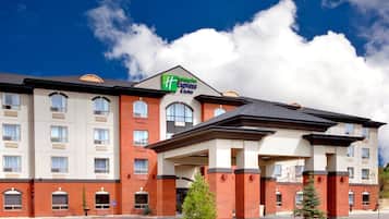Welcome to the Holiday Inn Express & Suites, featuring a modern architectural design with a covered entrance and large windows.