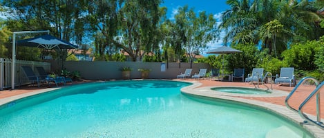 Una piscina al aire libre, tumbonas