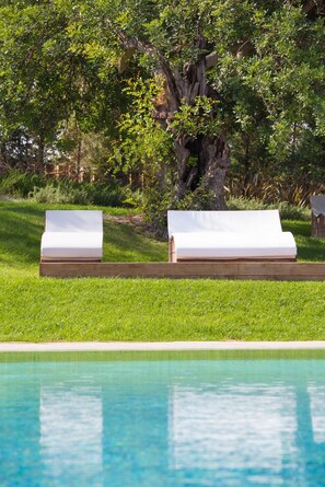 A poolside area with two lounge chairs and a wooden deck. - Ozadi Tavira Hotel (Tavira)