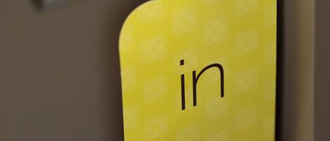 A yellow door card with a metal handle and text in Portuguese.