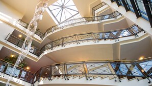 Un atrium à plusieurs niveaux, doté de rampes en verre et d’un élément décoratif central.