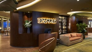 A reception area with a curved desk, a sofa, and a sign that reads "DESARM. "