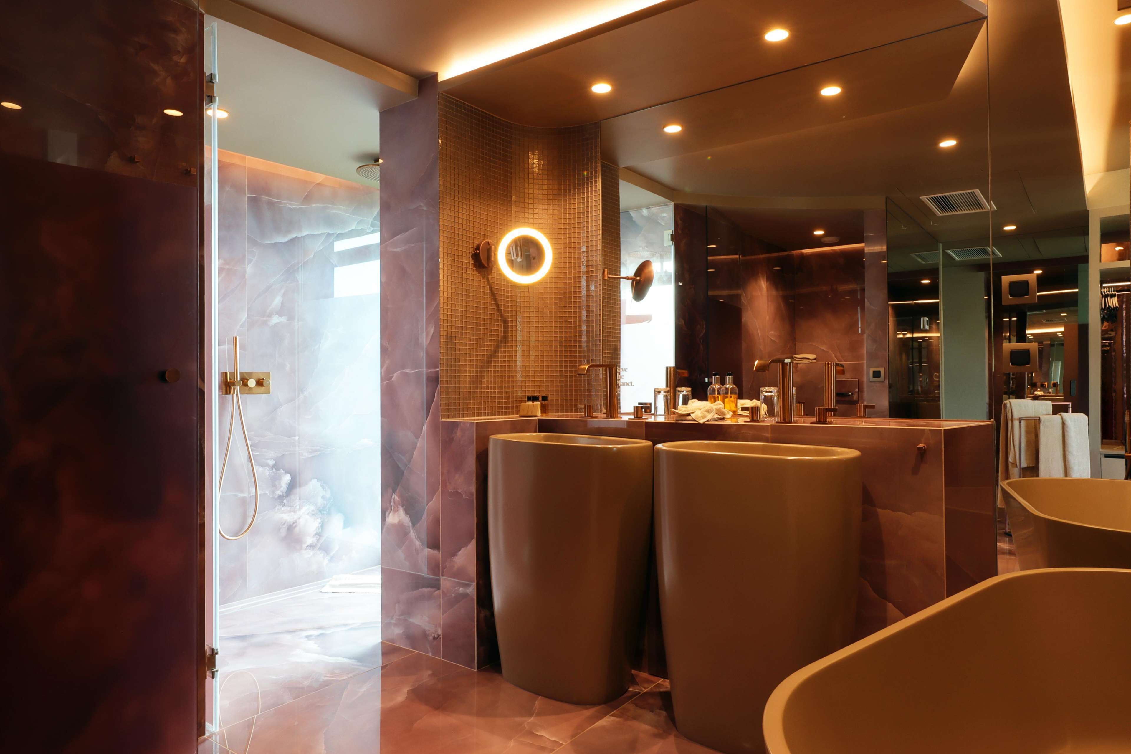Un baño moderno con cabina de ducha de vidrio, tocador con espejo y bañera.