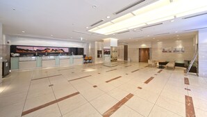 A spacious lobby with a reception desk, seating area, and a staircase. - Hearton Hotel Higashishinagawa (Tokyo)
