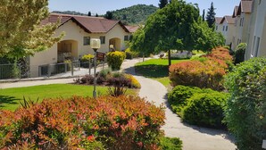 Un quartier résidentiel doté d’un sentier, de jardins bien entretenus et de maisons aux toits recouverts de tuiles rouges.