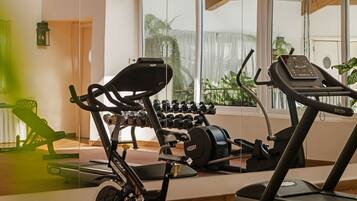 A home gym with exercise equipment, including a treadmill, elliptical, and dumbbells.