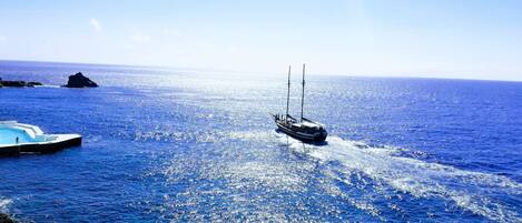A sailboat on a calm sea with a clear sky.