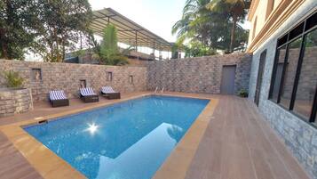 Una piscina al aire libre, sombrillas