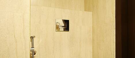A bathroom with a toilet, a shower, and a mirror.