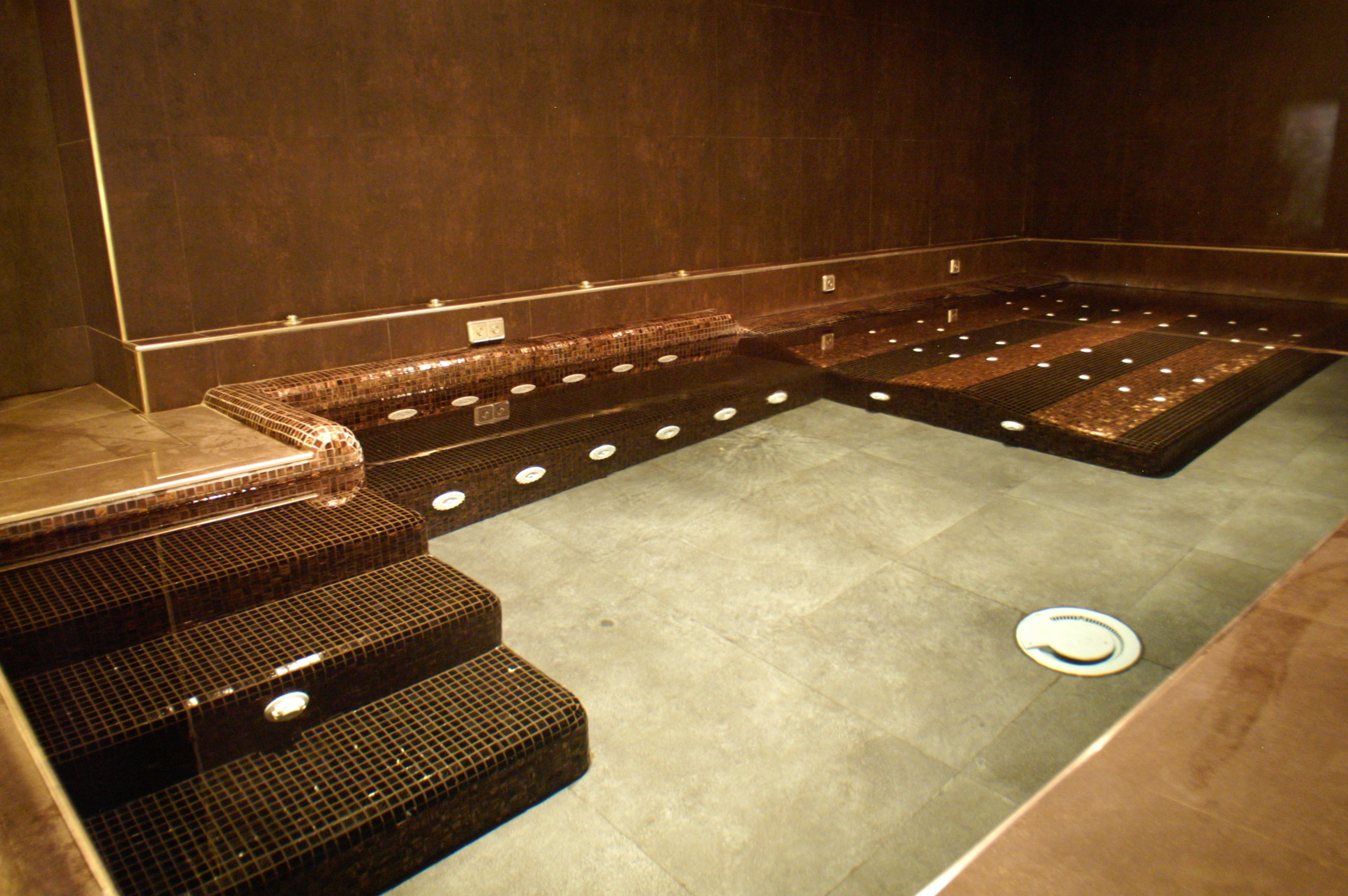 A sauna with multiple benches and a tiled floor.