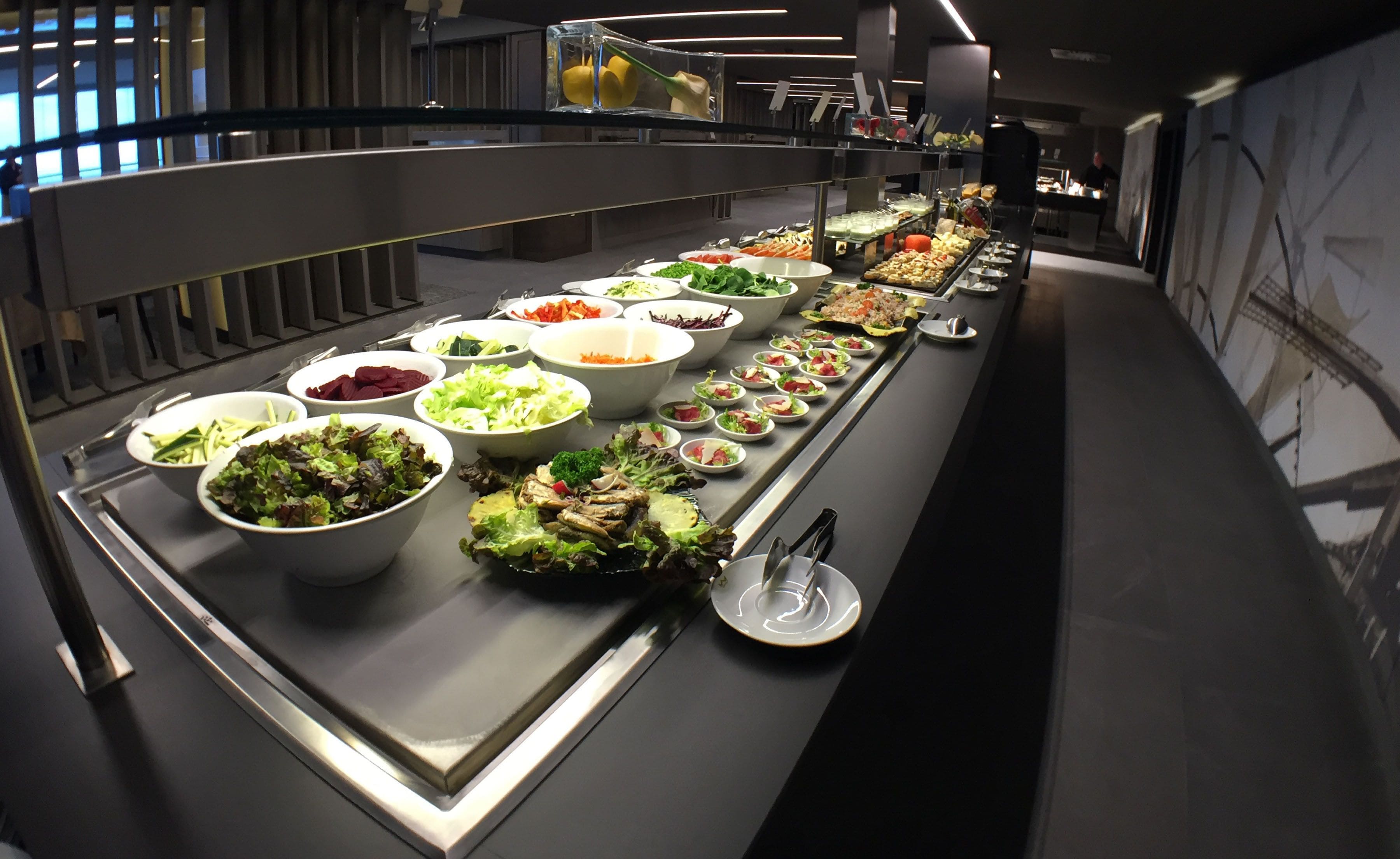 A buffet with various food options including salads, vegetables, and meats.