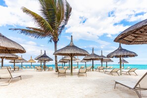Plage, sable blanc, chaises longues, parasols