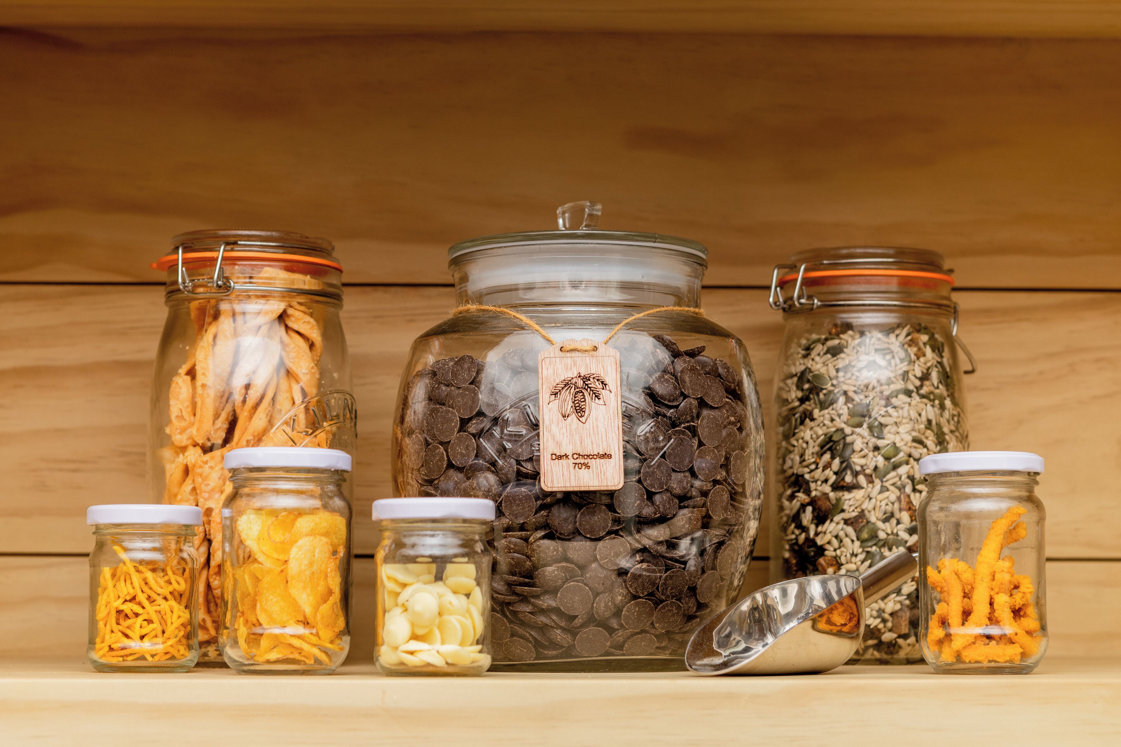 Various glass jars with labels containing different food items like chocolate chips and dried fruits.