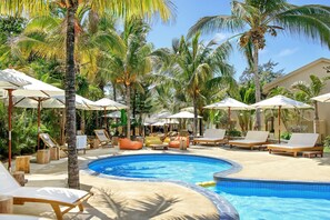 Een buitenzwembad, ligstoelen bij het zwembad