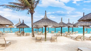 Plage, sable blanc, chaises longues, parasols