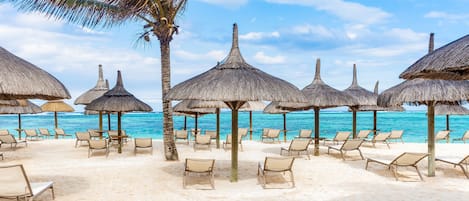 Plage, sable blanc, chaises longues, parasols