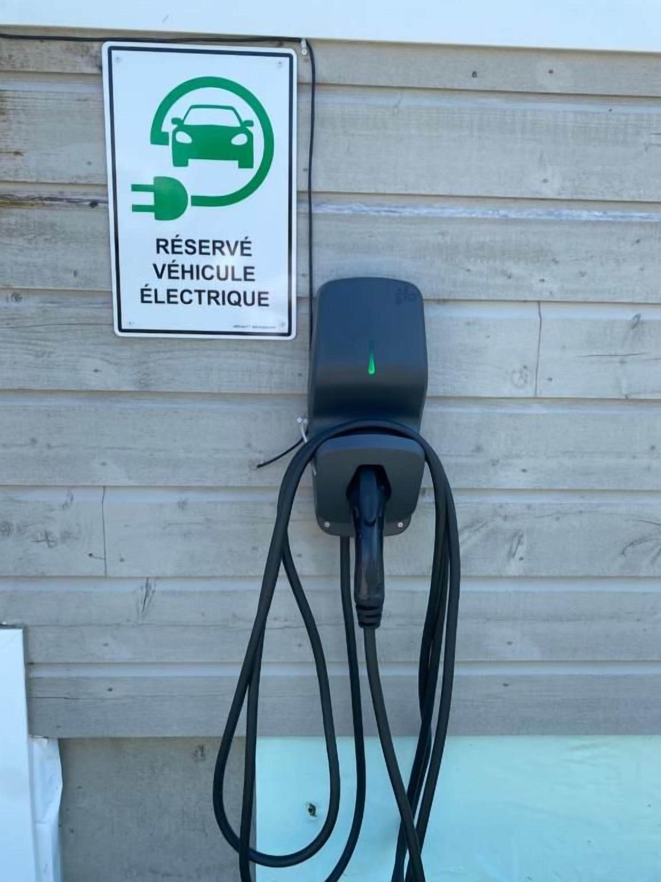 Une borne de recharge pour véhicules électriques, avec un panneau indiquant qu’elle est réservée aux véhicules électriques.