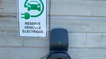 Une borne de recharge pour véhicules électriques, avec un panneau indiquant qu’elle est réservée aux véhicules électriques.