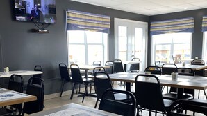 A breakfast setting with tables, chairs, and a variety of pastries and beverages. - Hotel Motel Panorama de Perce (Perce)