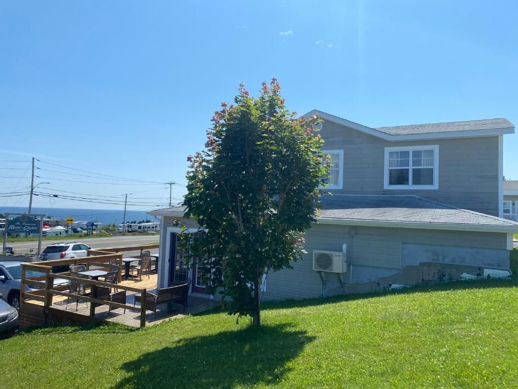 A residential property with a patio area, a tree, and a house with a sloped roof.