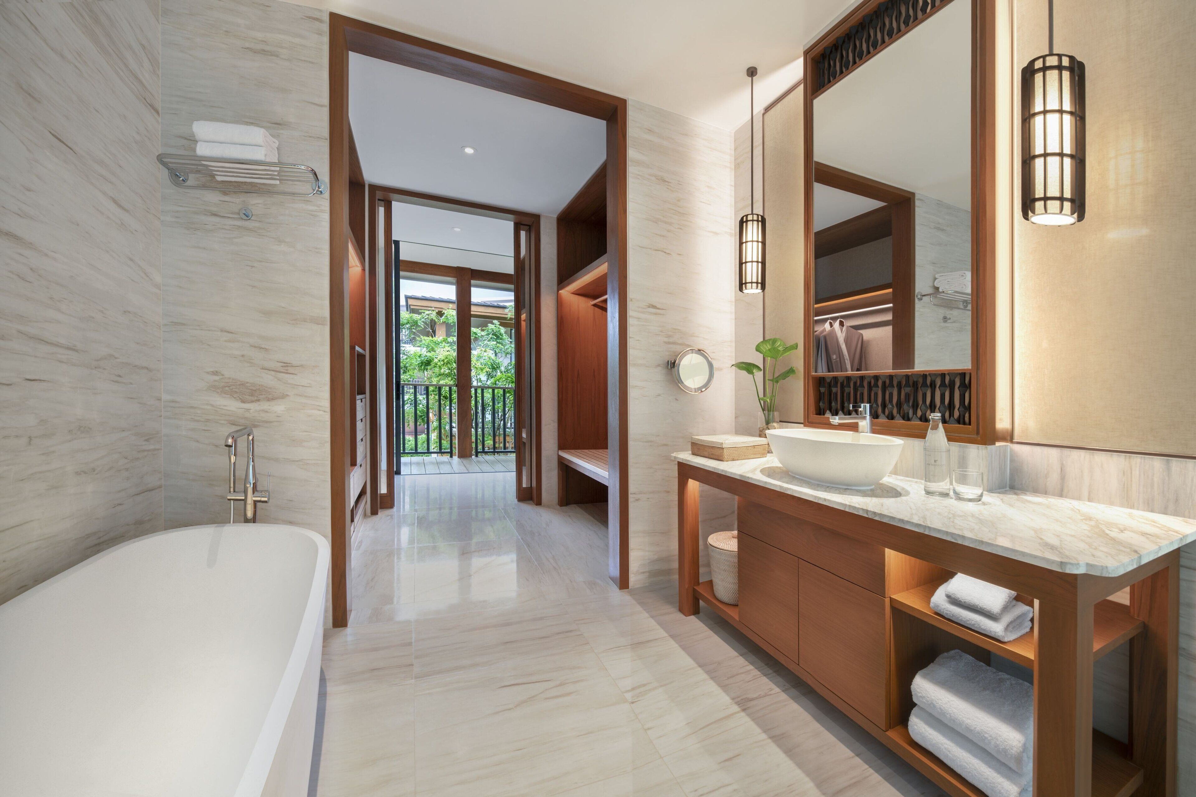 A modern bathroom with a freestanding bathtub, a large mirror, and a vanity with a sink.