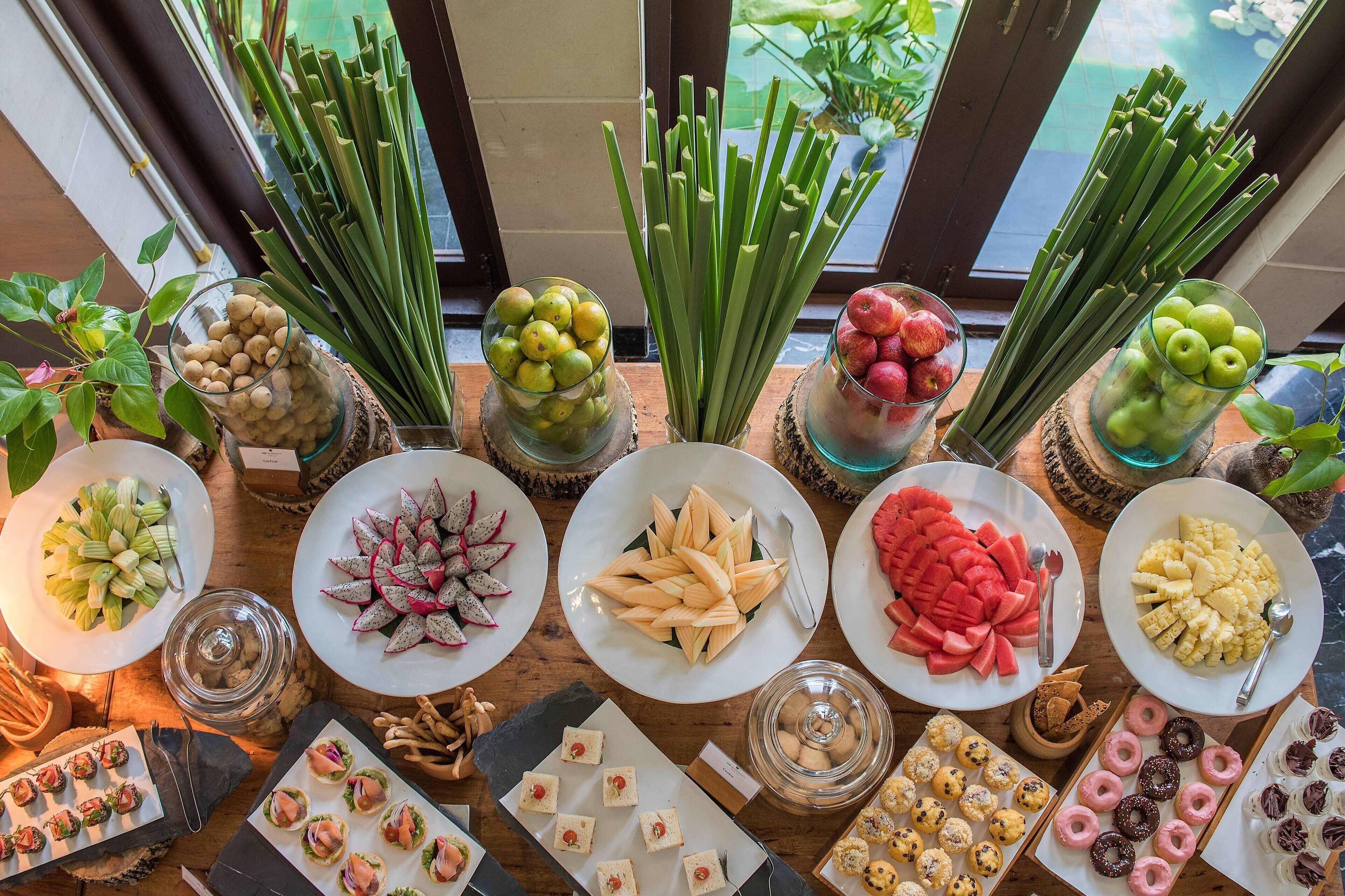 Diversos alimentos sobre una mesa, como frutas, verduras y pasteles.