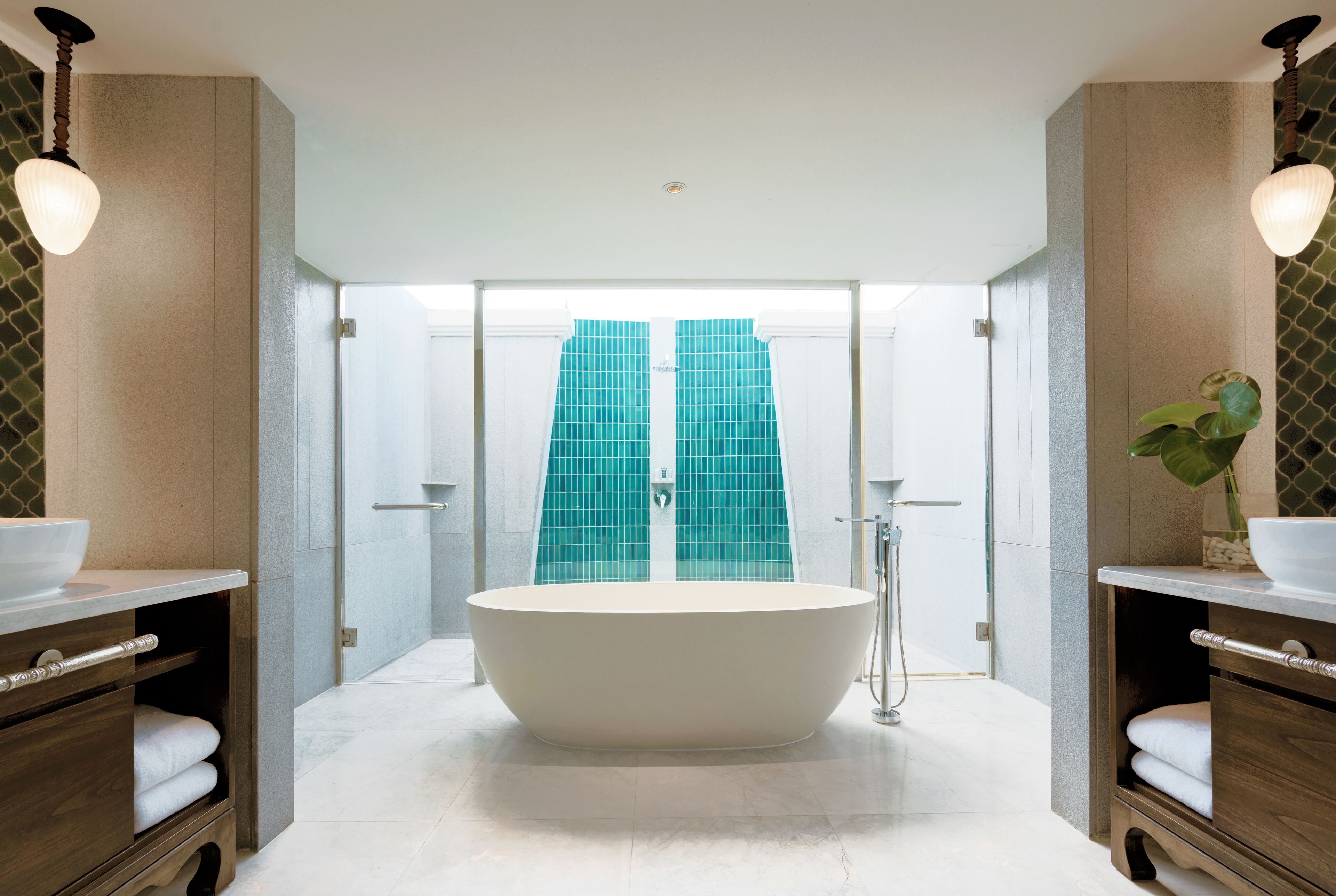 A modern bathroom with a freestanding bathtub, wooden vanity, and a large mirror.