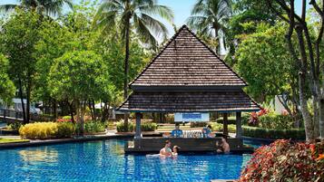 Una piscina al aire libre, sombrillas, sillones reclinables de piscina