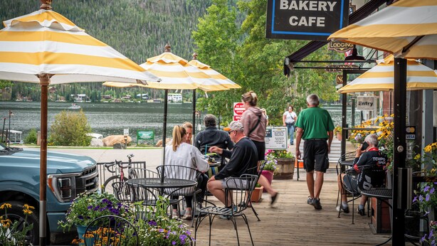 A bakery cafe with outdoor seating, a lake view, and a sign indicating lodging availability. - Spirit Lake Lodge (Grand Lake)