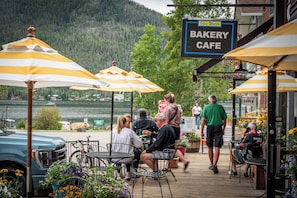 A bakery cafe with outdoor seating, a lake view, and a sign indicating lodging availability. - Spirit Lake Lodge (Grand Lake)