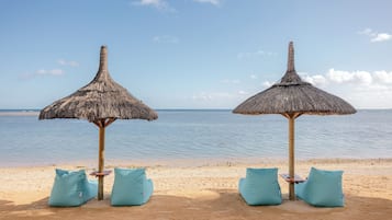 On the beach, white sand, sun-loungers, beach umbrellas