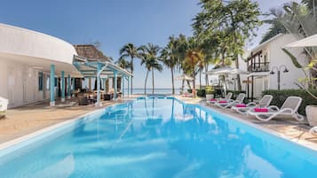 Alberca al aire libre, sombrillas en la alberca y camastros