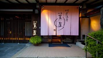 A traditional Japanese building entrance with a large banner displaying Japanese characters.