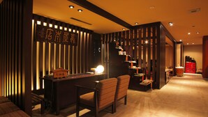 A modern interior with a reception desk, seating area, and a wooden partition with vertical slats. - Kaidou Roman Onyado Tsutaya (Kiso)