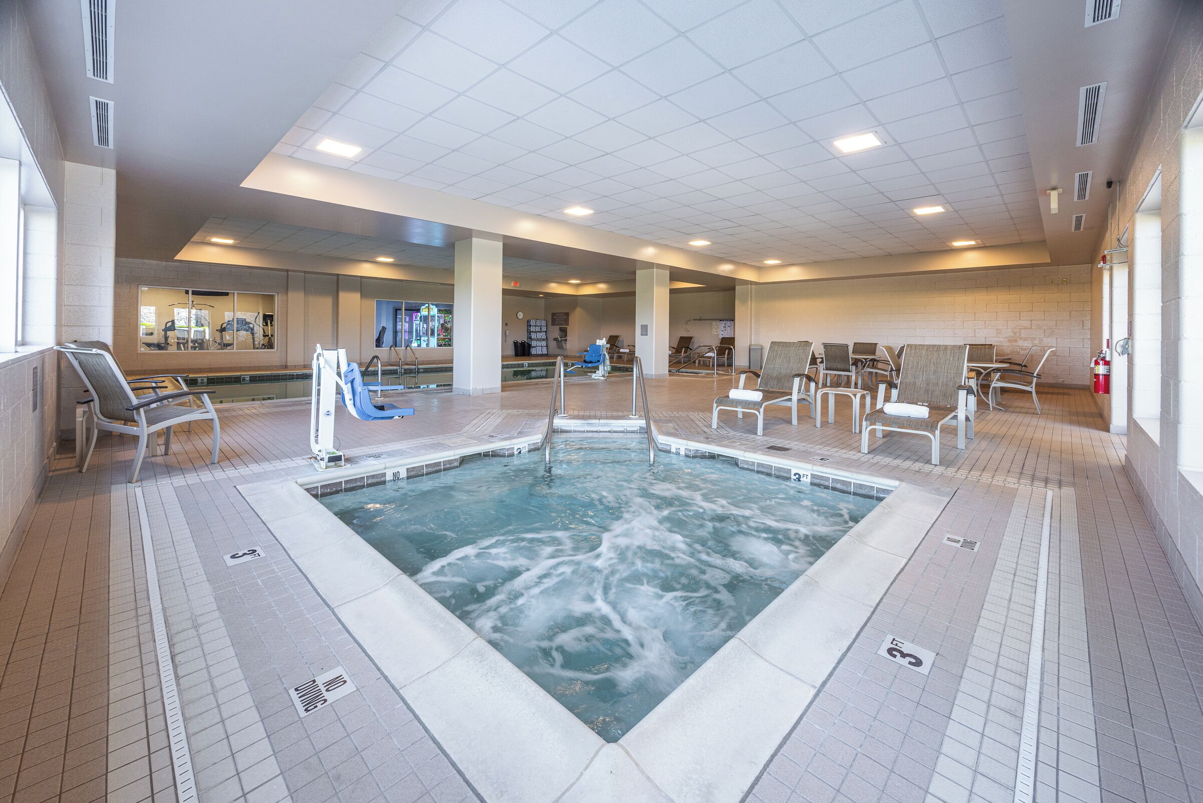 Ein großer, überdachter Pool mit mehreren Sitzbereichen und einem Empfangsschalter im Hintergrund.