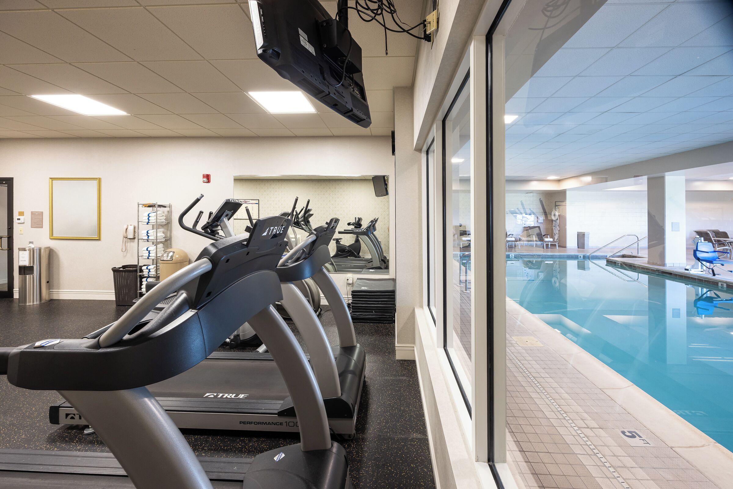 Una palestra con tapis roulant e zona piscina.