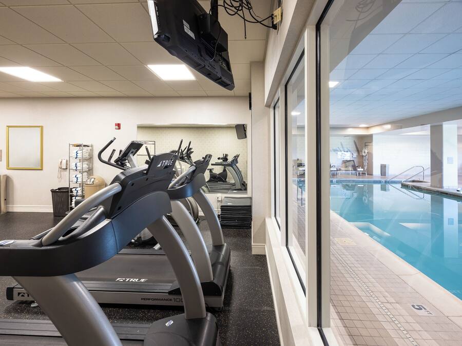 Una palestra con tapis roulant e zona piscina.