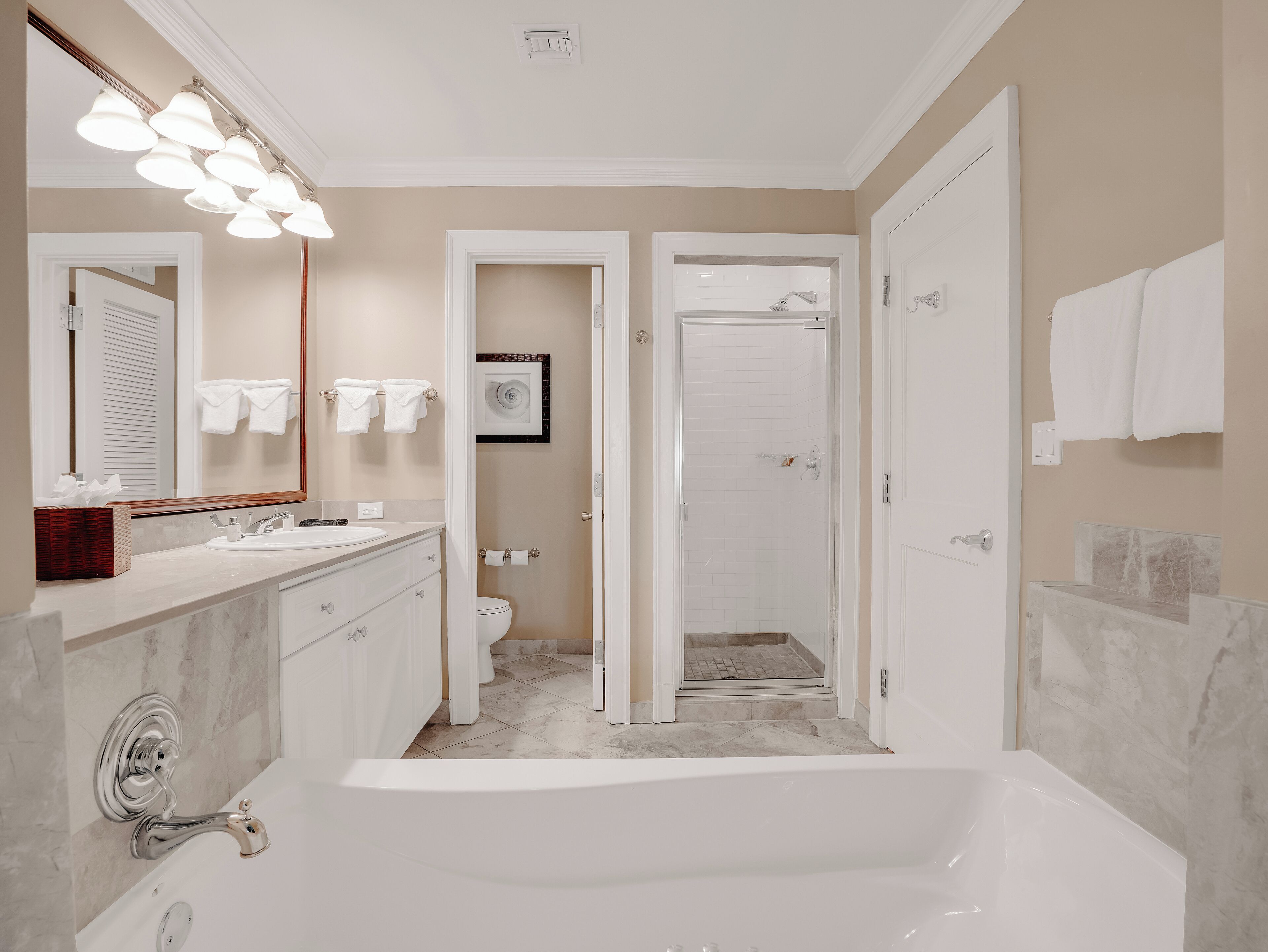 Une salle de bain moderne dotée d’une grande baignoire, d’un meuble-lavabo avec miroir et d’un espace douche.