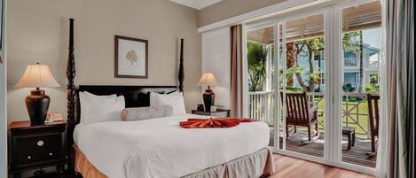 A hotel room with a large bed, two bedside tables with lamps, a ceiling fan, and a view of a pool and building through a sliding glass door.