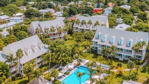 An aerial view of a resort with multiple buildings, a swimming pool, and lush greenery. - Valentines Resort & Marina (Dunmore Town)
