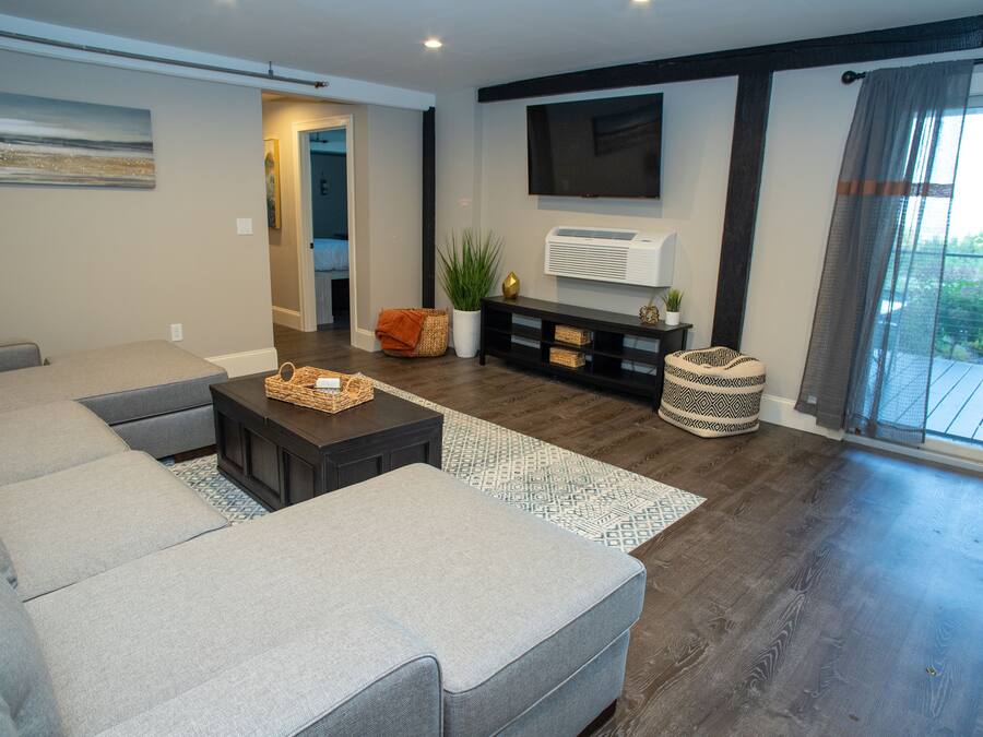 Una sala de estar moderna con un sofá modular, una mesa de centro y un televisor de pantalla plana montado en la pared.