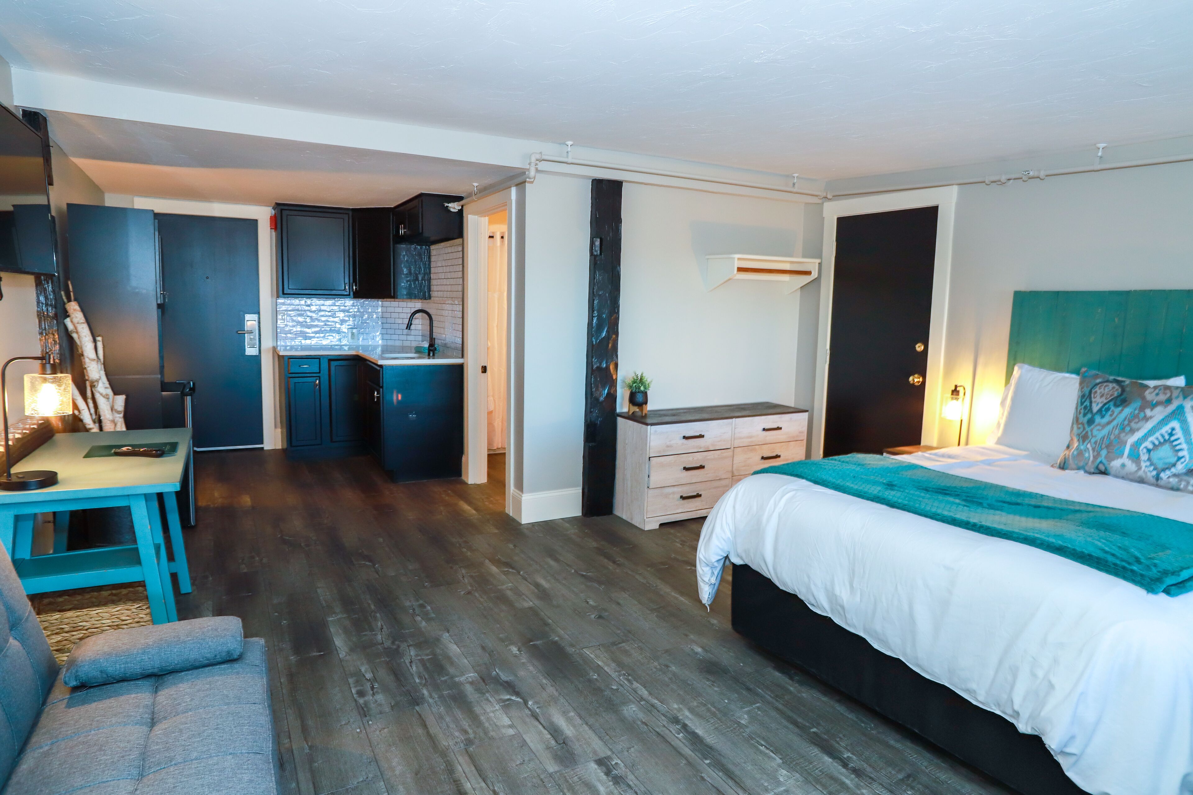 Un dormitorio pequeño con cama, mesita de noche y un pequeño espacio de escritorio.