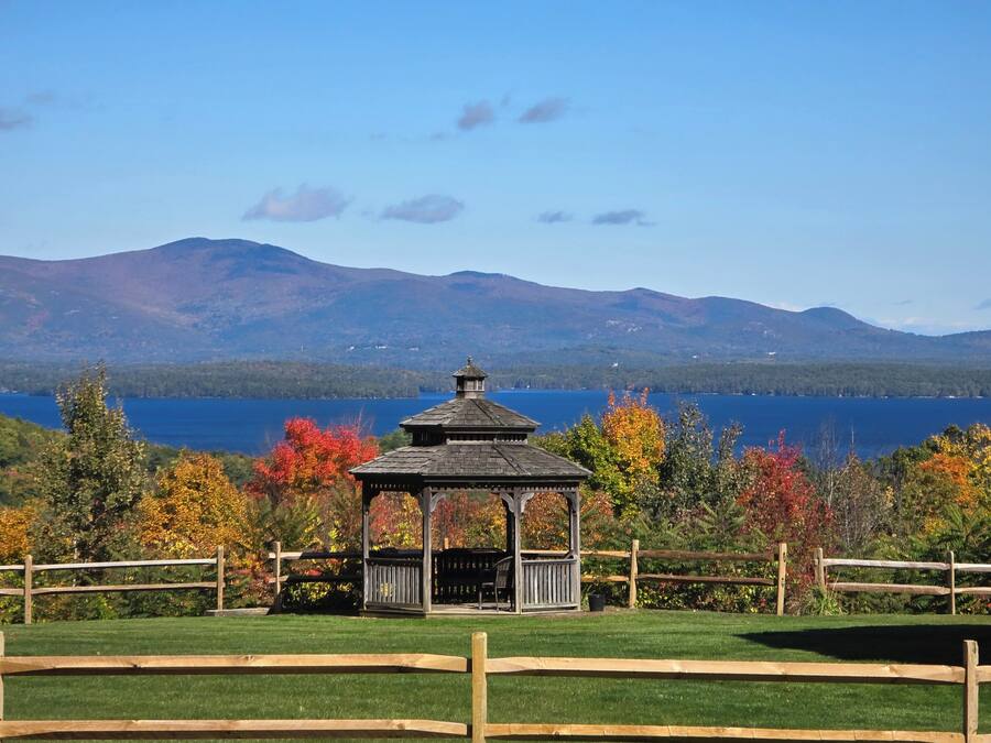 A gazebo with a view of a lake and mountains in the background.