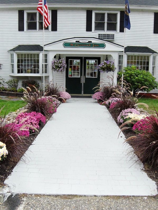 A building with a green door and a sign that reads "The Gunstock Inn." - Gunstock Inn & Suites (Gilford)