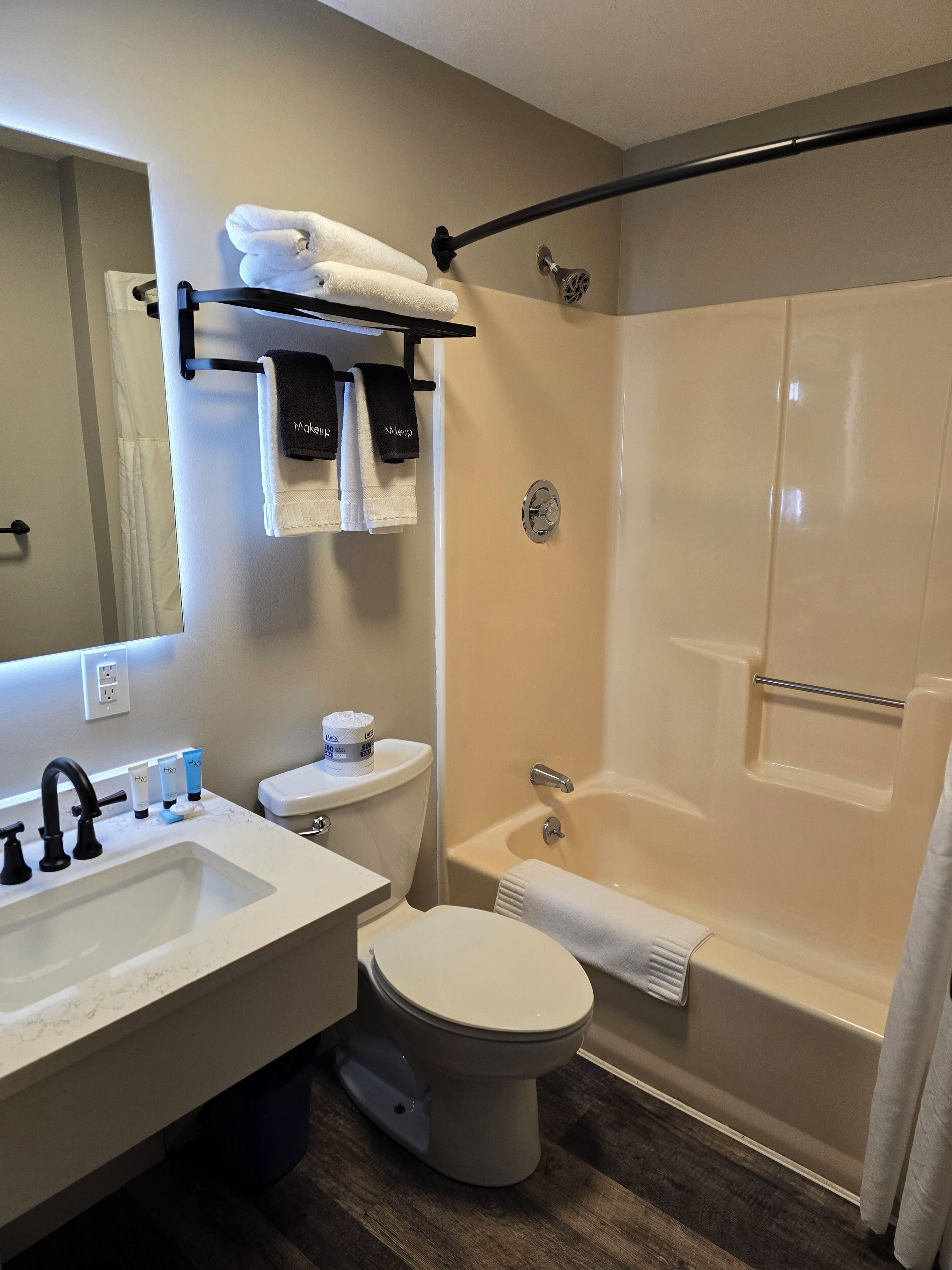 Un baño con lavamanos, inodoro, bañera y cortina de ducha.