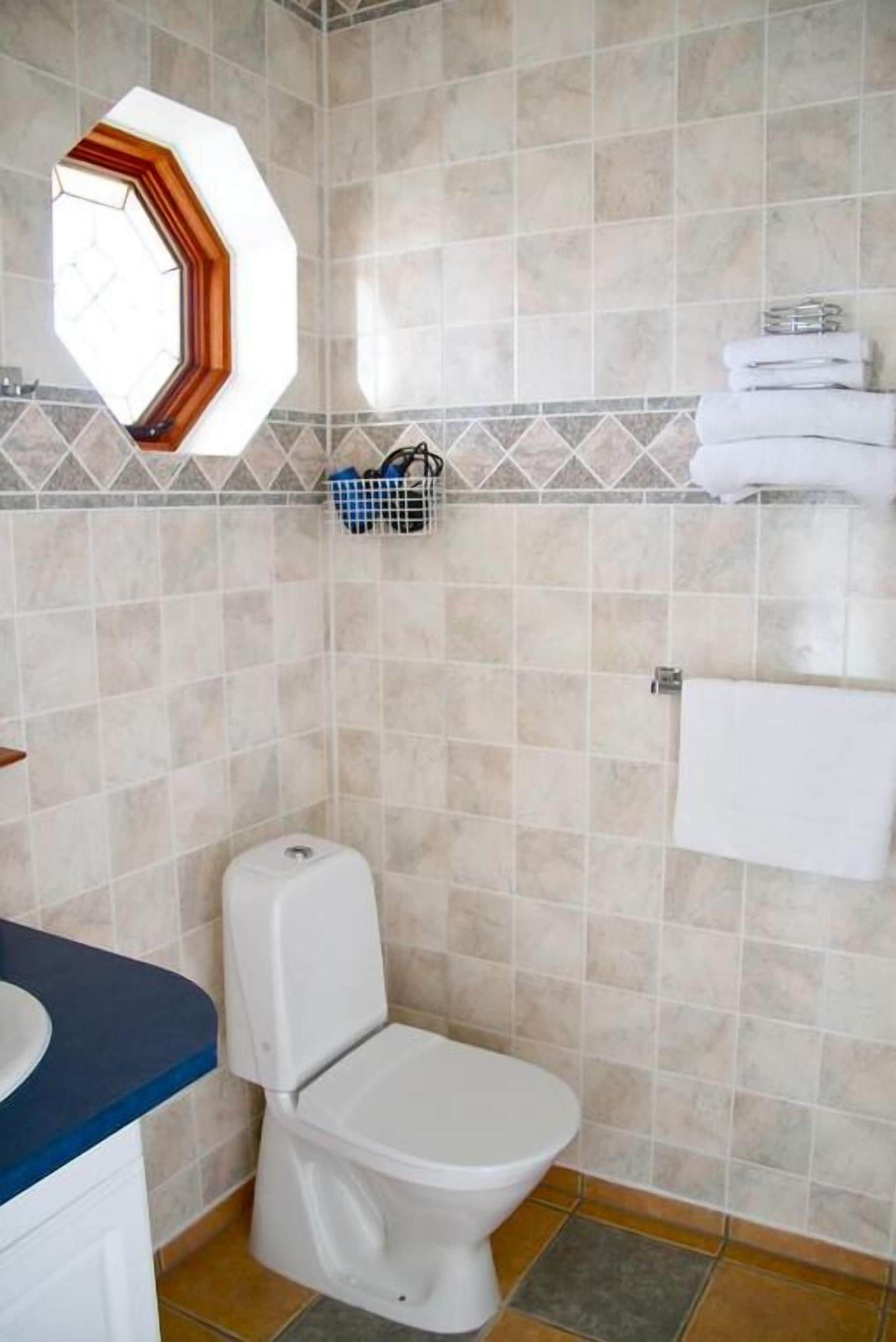 A bathroom with a toilet, a sink, and a towel rack.
