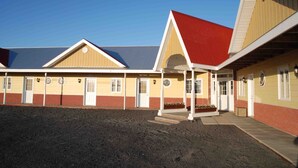 A building with a covered entrance and multiple doors, likely a motel or inn. - Hotel Vogar (Vogar)