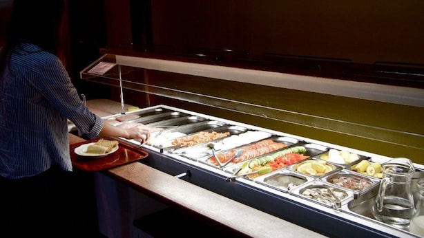 A buffet with various food items and a person serving food. - Hotel Vogar (Vogar)