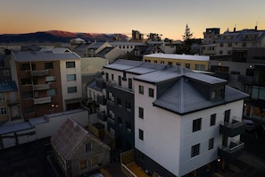 A multi-story residential building with balconies, a flat roof, and a mountainous backdrop. - Reykjavik4you Apartments (Reykjavik)